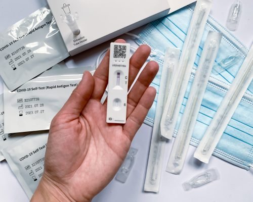female-hand-is-holding-covid-19-rapid-self-testwoman-is-testing-herself-home-with-using-home-set