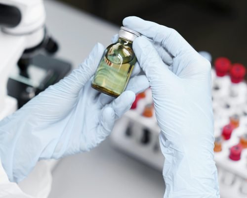 high-angle-female-researcher-laboratory-with-vaccine-bottle